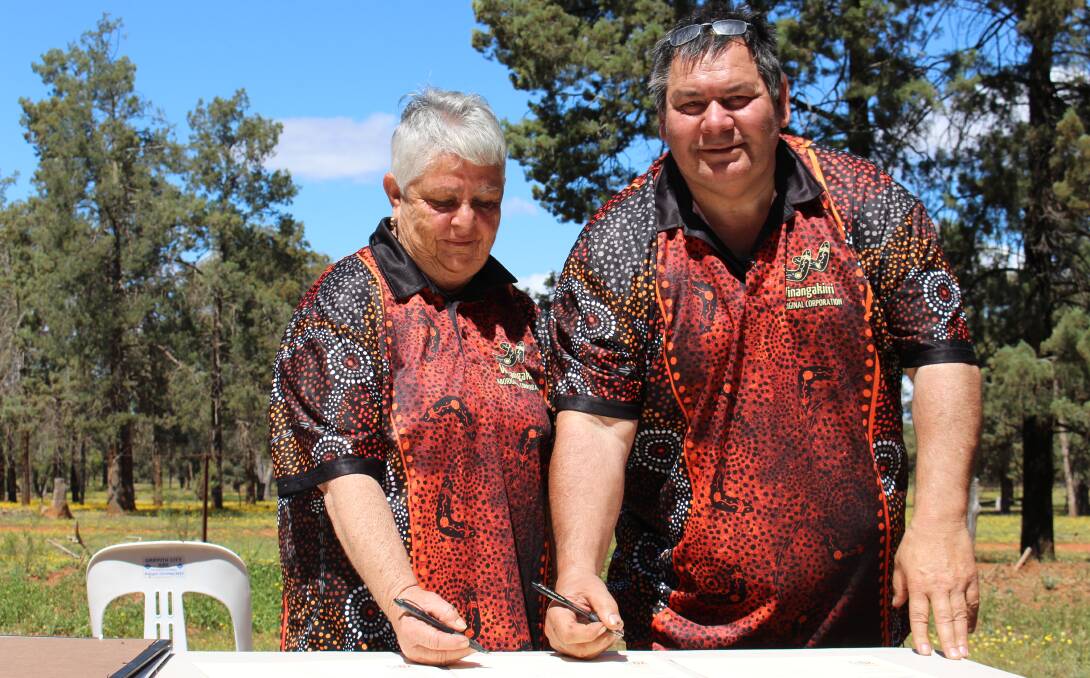 EMOTIONS RUN HIGH: Norma O'Hara and Lawrence Clark from the Winangakirri Aboriginal Corporation sign the Certificate of Grant.