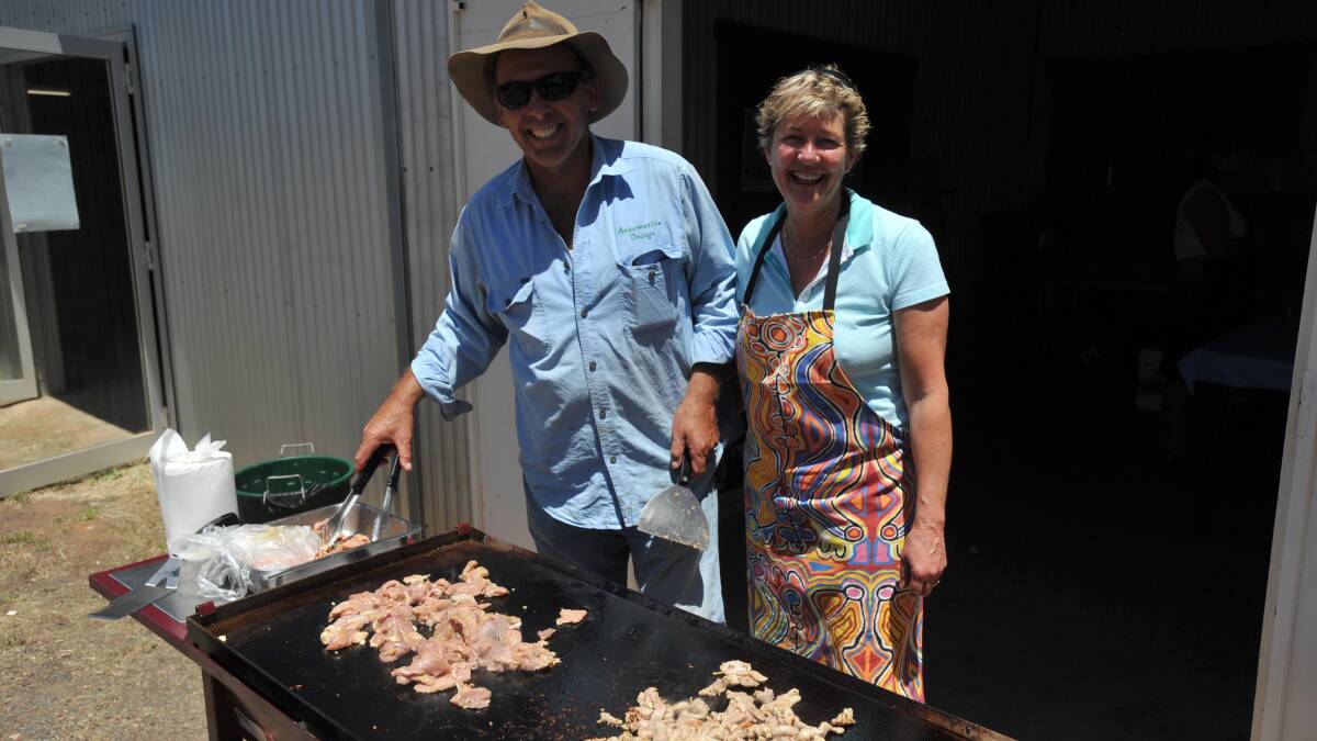 Joy Geddes and John Bianchini help with the barbecue.