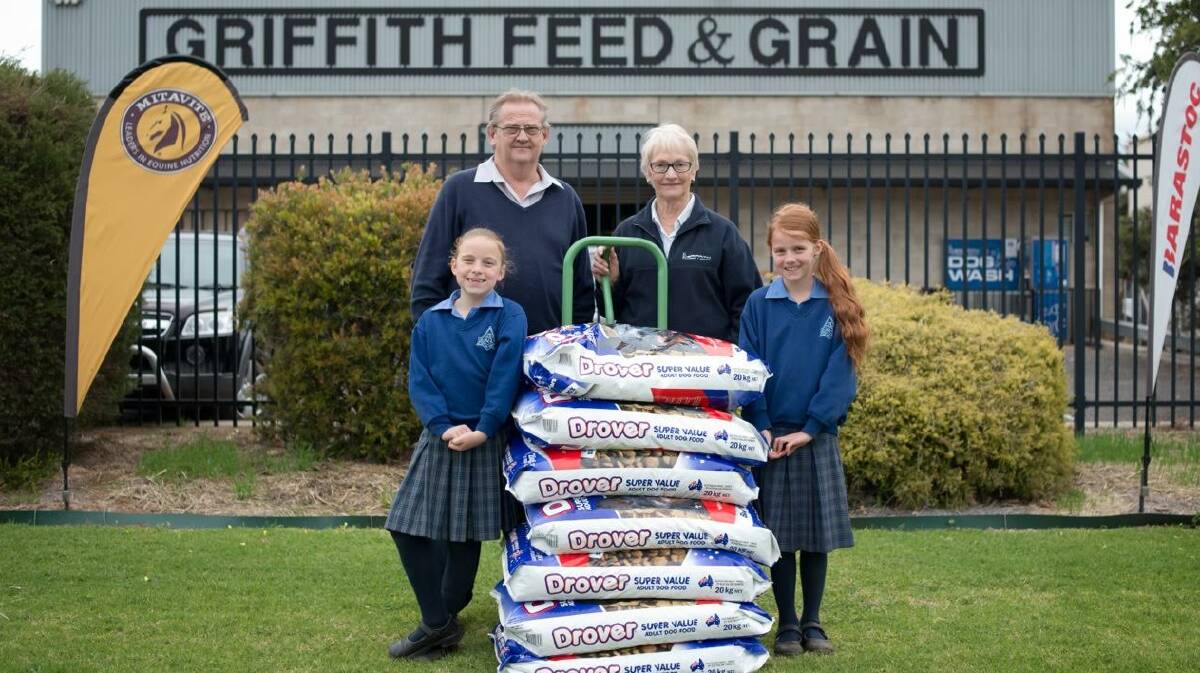 GIVING: India Hyde and Elsie Barton raised money to buy dog food from Phylis Dart from Griffith Feed & Grain to donate to Ken Rebetzke from Needy Paws