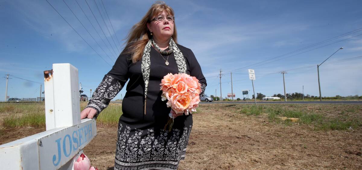 RELIEF: Roseanne Bianchini stands by a memorial to her son Joseph at the soon-to-be upgraded Yoogali intersection. Picture: Anthony Stipo.
