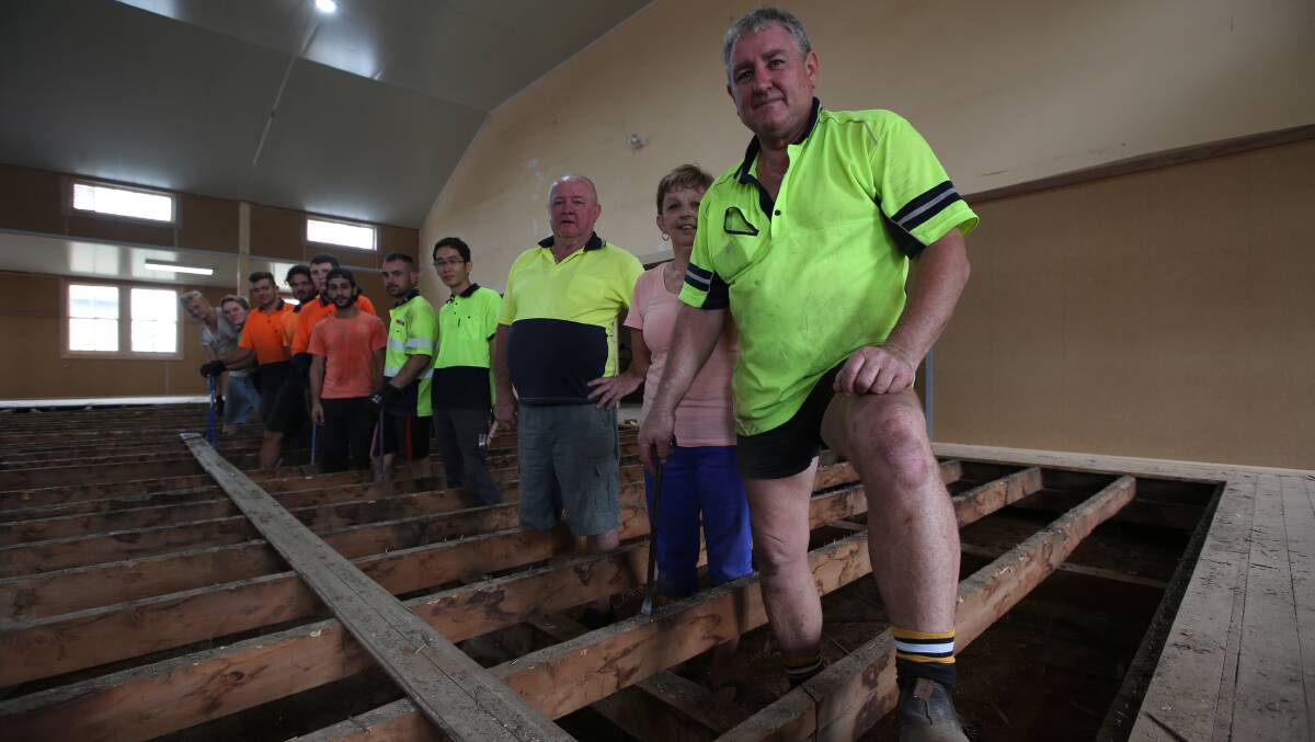 BIG JOB: Ross and Claire Davidson with their building crew as they prepare to pull up the last floorboard in Woodside Hall. PHOTO: Anthony Stipo.