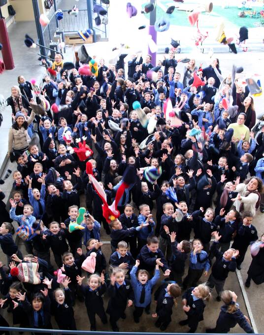 BEANIES FOR BRAIN CANCER: Students at St Mary's Yoogali throw their beanies in the air on Tuesday. Picture: Anthony Stipo.