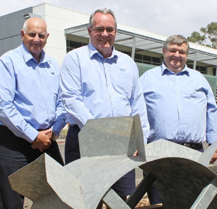 FOUR DECADES OF SERVICE: Murrumbidgee Irrigation’s Noel Heath, Eddy McDonald and Tom Thompson standing behind the Dethridge Wheel at the Hanwood office. Picture supplied.