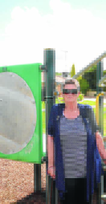 RUINED: Gwen Beaton stands next to the playground burnt by vandals. Picture: Ben Jaffrey