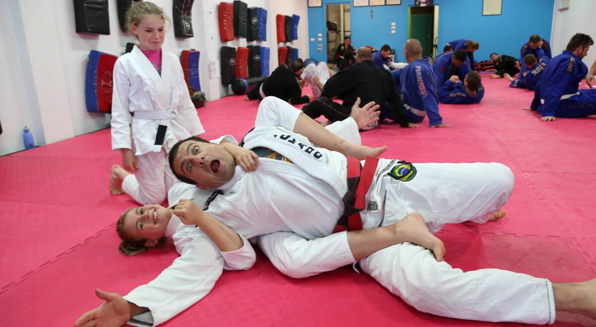 TAP OUT: Sarah Zambon, 11, gets Carlos Machado into a submission hold as Madeline Proud, 11, looks on. Picture: Anthony Stipo