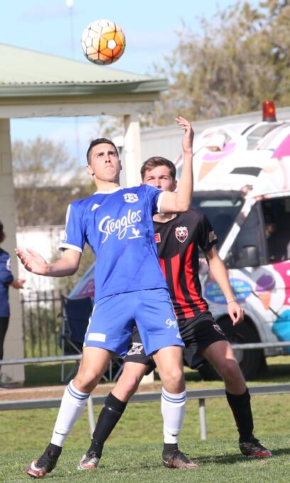 ON THE PRIZE: Hanwood FC's Jacob Zanatta eyes a falling ball as he holds off Leeton's Jake Shelton. Picture: Anthony Stipo