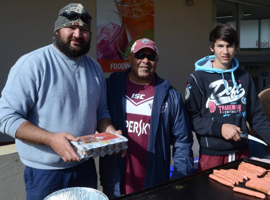 COMMUNITY: Tommy Coe, Damian Thorne and Jai Coe cook a barbecue to raise funds for the family of Christopher Beale. Picture: Ben Jaffrey.