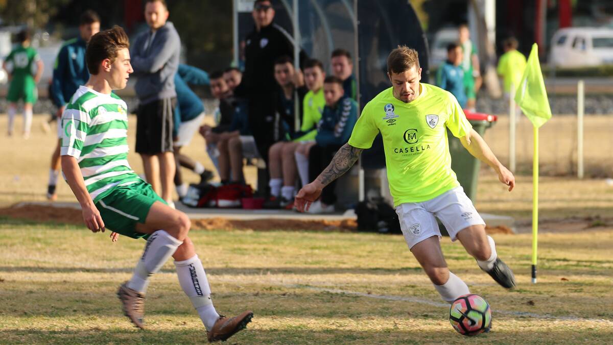 KNOCKING IT AROUND: Rhinos' Darren Bailey looks to get around the Tuggeranong defence during their NPL match. PHOTO: Andrew McLean