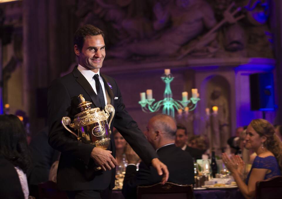 TAKING IT HOME: Roger Federer arrives with his trophy for the Champions Dinner following his Wimbledon win over Marin Cilic. PHOTO: Jon Buckle/AELTC, Pool via AP