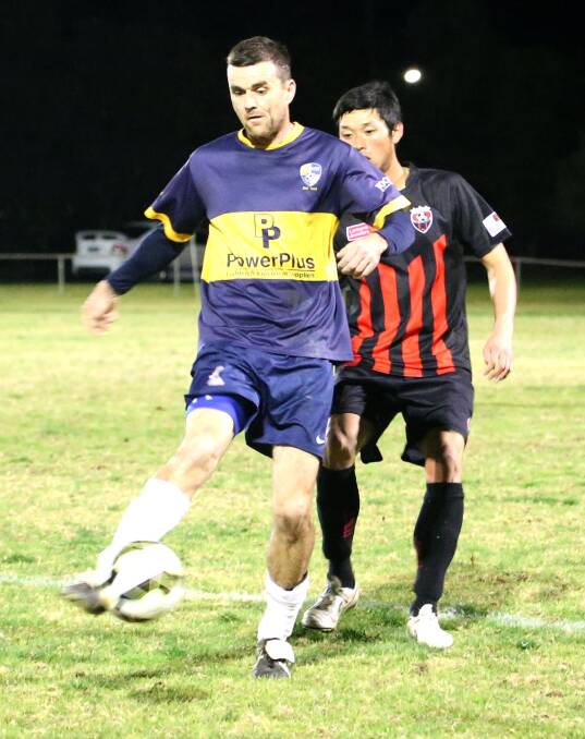 HARD WORK: YSC's Grant Davidson shields the ball from Leeton's Keisuke Inove. Pictures: Anthony Stipo