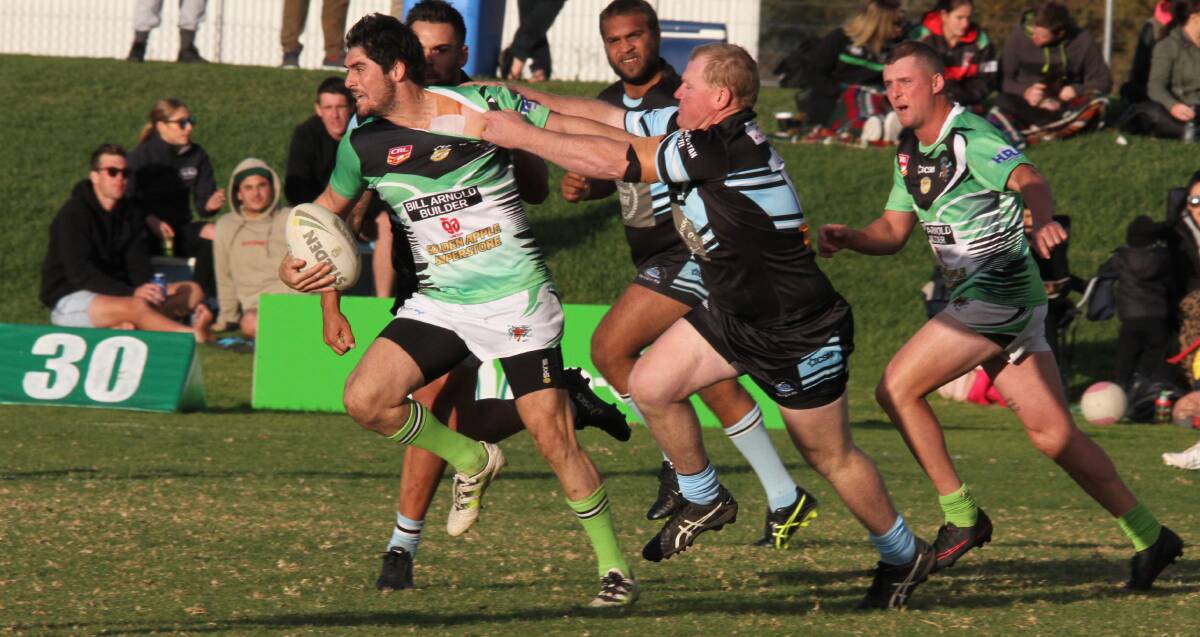 BREAKING STRENGTH: In spite of his efforts Leeton's Brayden Scarr is unable to break free from the Sharks' defender Mark Bendall. Photo: Ron Arel