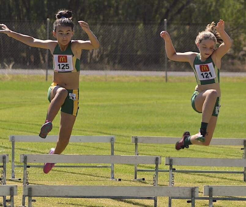TAKING FLIGHT: Sarah Cully (left) and Lily Haddrill clear the hurdles during their race at the zone championships. Picture: supplied