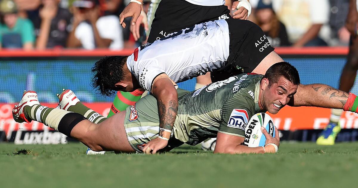 GOING DOWN: Rabbitohs hooker Issac Luke tackles the Raiders' Paul Vaughan at Barlow Park in Cairns. Picture: Getty Images
