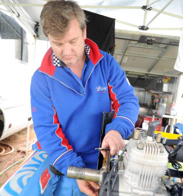 TINKERING: Thomas Petrovish performs maintenance on his kart.