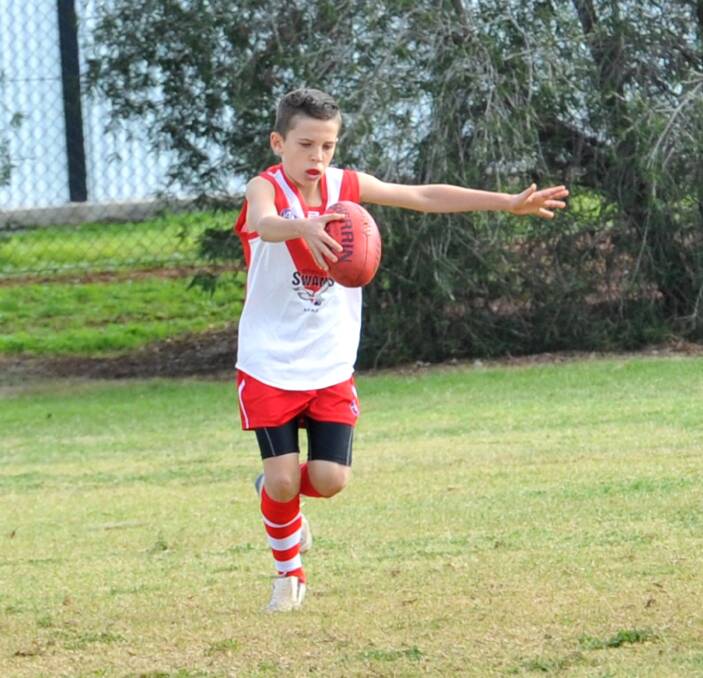 WIND UP: Griffith Swans White under 13s player Angus Brown prepares to unleash a big kick up the field. Picture: Anthony Stipo