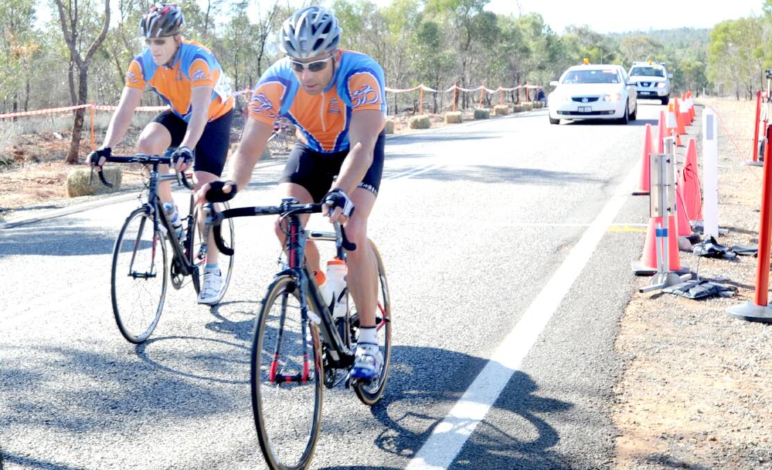 TOP RIDE: Griffith competitors Phil Twigg and Craig Tilston keep their legs pumping at Scenic Hill during the road race.