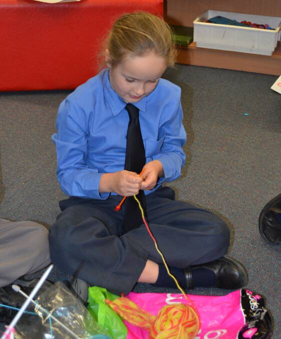 KNITTING: Year Three student Liza Twaddell helps knit blanket squares.