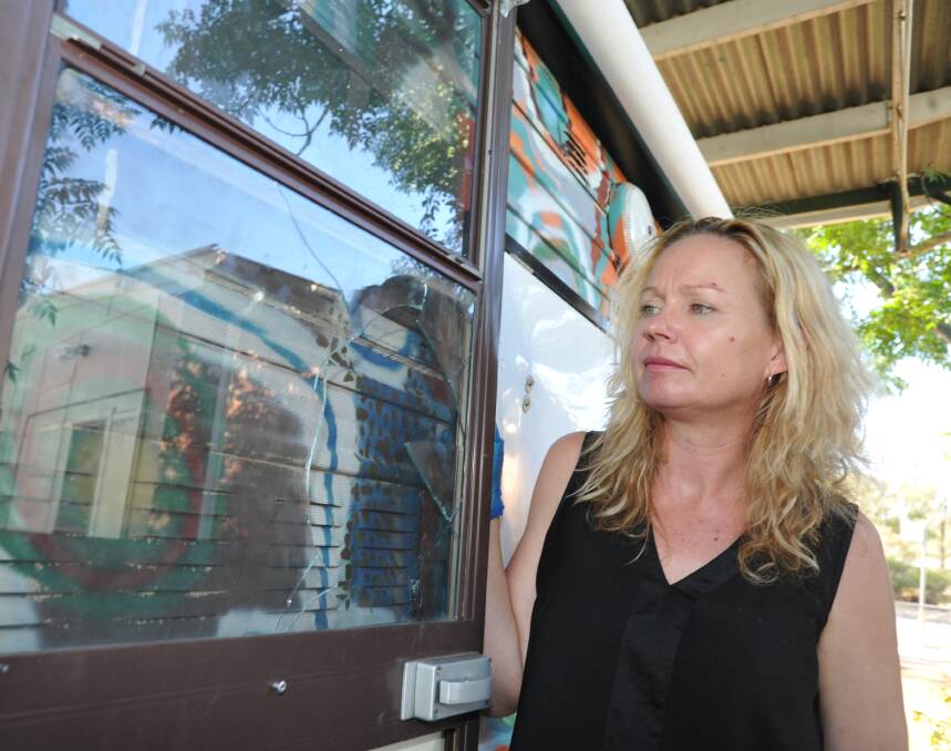 BREAK-IN: Barbara Penninga inspects a broken window on the Griffith Carevan, which was broken into. Picture: Stephen Mudd.