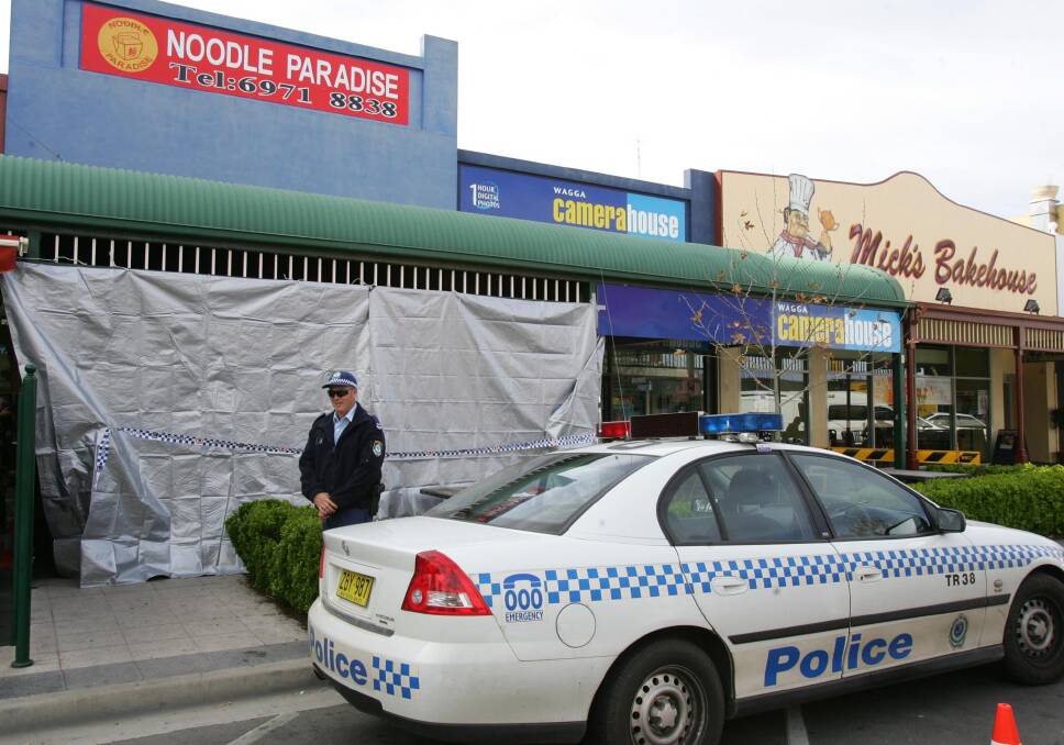 CRIME SCENE: A police officer stands guard at the front of Noodle Paradise after a crime scene was established.