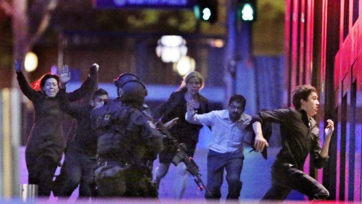 Five hostages run from the Lindt Cafe  building towards Special Operations Police in Martin Place on December 16 last year. Photo: Andrew Meares