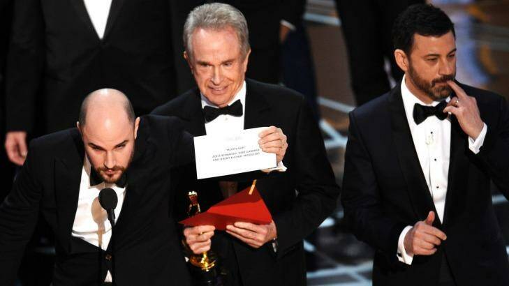 Jordan Horowitz shows the envelope revealing <i>Moonlight</i> as the real winner of best picture at the Oscars, with Warren Beatty and Jimmel Kimmel. Photo: Chris Pizzello 