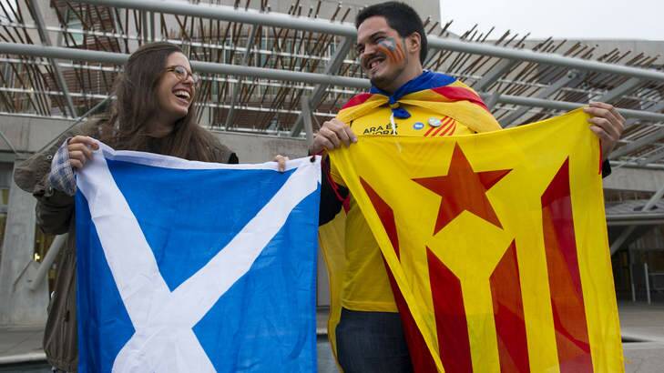 A Catalan supporter (right) of the 'Yes' campaign holds up a flag beside a pro-independence supporter outside the Scottish Parliament in Edinburgh. Photo: AFP