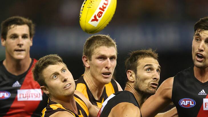 Eyes on the ball... Hawthorn's Liam Shiels and Essendon's Jobe Watson compete for possession. Photo: Pat Scala