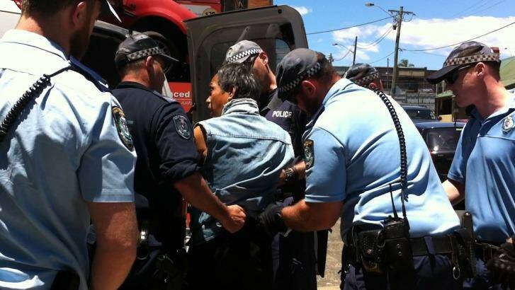 Mr Ngo was arrested and escorted into a police vehicle in St Peters.  Photo: WestConnex Action Group