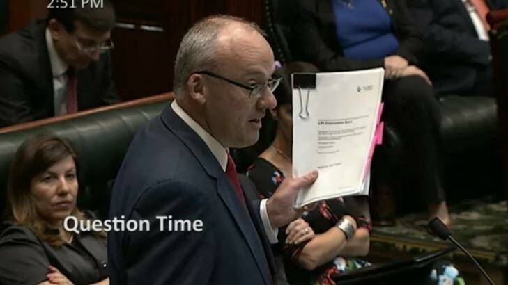 Opposition leader Luke Foley lifts a leaked copy of the land titles registry privatisation contract during Question Time on Thursday. Photo: Screenshot