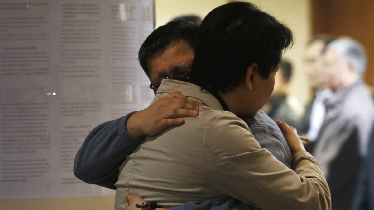 Family members of a passenger onboard the missing Malaysian Airlines flight MH370 hug each other as they wait for news about the missing plane at a hotel in Beijing March 20, 2014. Photo: Reuters.