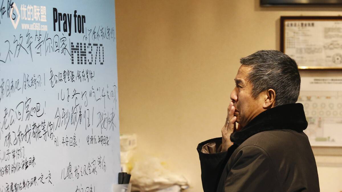 A family member of a passenger onboard the missing Malaysian Airlines flight MH370 cries as he watches a message board dedicated to passengers onboard the missing plane at a hotel in Beijing March 20, 2014. Photo: Reuters.