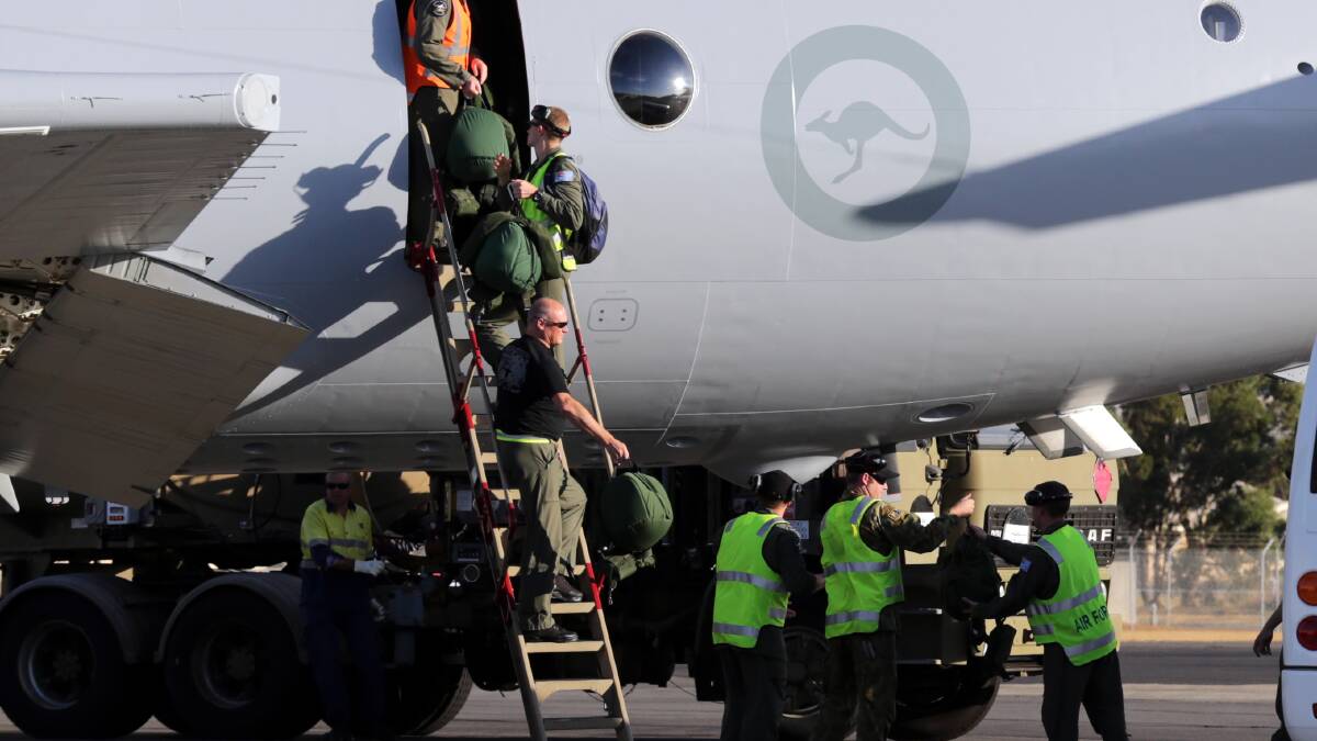 Royal Australian Air Force (RAAF) crew members from of an AP-3C Orion maritime patrol aircraft walk down a ladder after they arrived in Perth March 20, 2014 after searching an area in the southern Indian Ocean for the Malaysia Airlines flight MH370. Photo: Reuters.