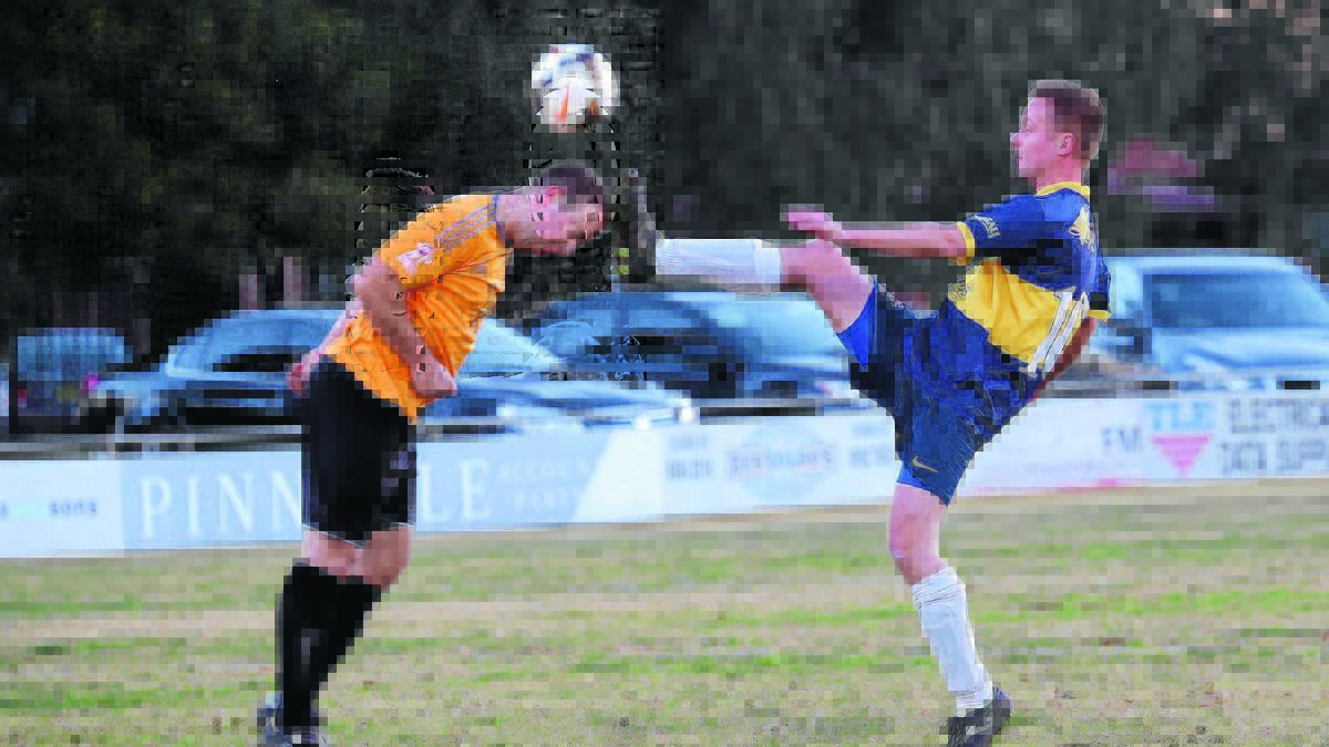 HEAD SCRATCHER: Yenda’s Colin Amery puts his head on the line against Yoogali SC’s Ryan Spencer at EW Moore Oval on Saturday. 