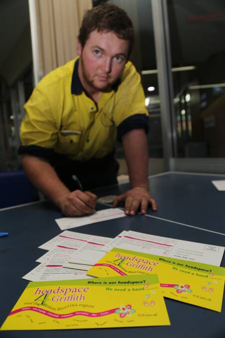SIGN HERE: TAFE student Chris Pilon throws his support behind Griffith's push for a Headspace facility in the city by signing one of the postcards created to raise awareness. Picture: Anthony Stipo 