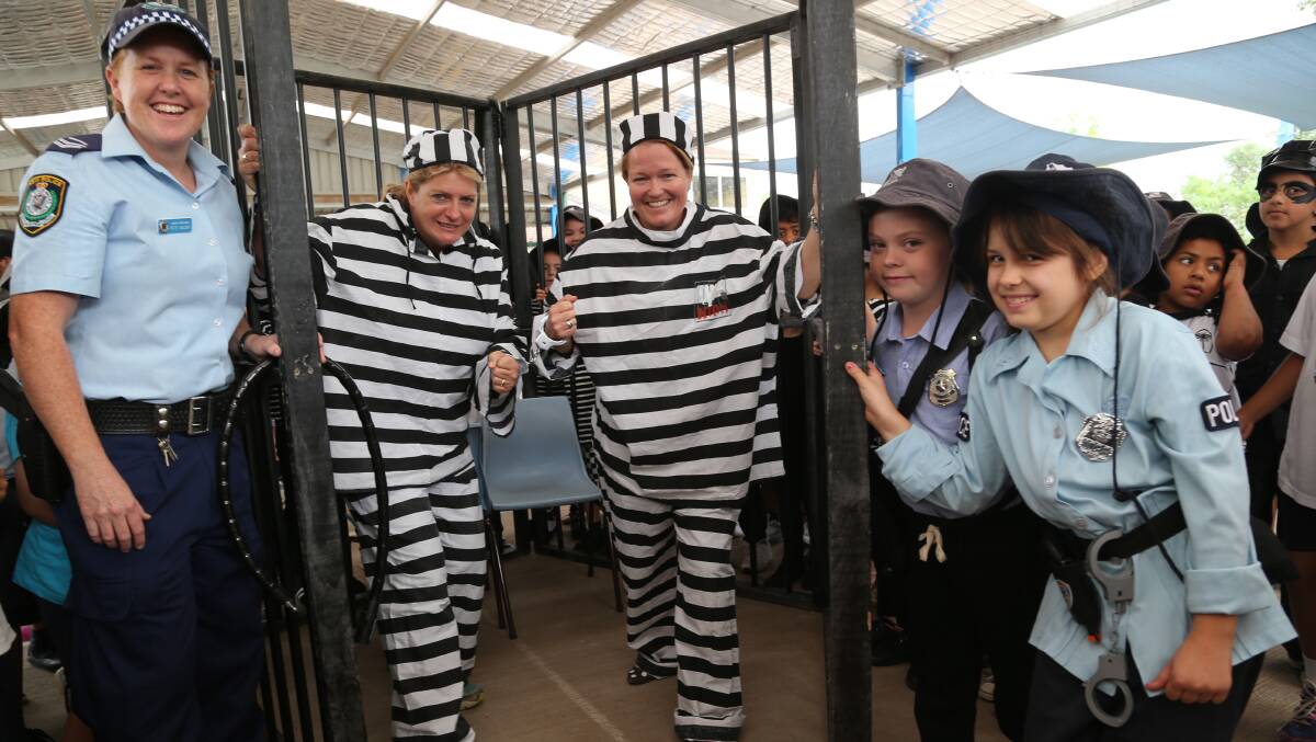 GOTCHA: Doing time on Wednesday at Griffith Public School are assistant principal Trish Campbell and principal Jude Hayman, thrown in the slammer by PCYC's senior constable Pete Naisby with back up from Sophia Kelsey, 8 and  Senay Kunduz, 9. They helped raise funds for Griffith PCYC's Time4Kids. Picture: Anthony Stipo 