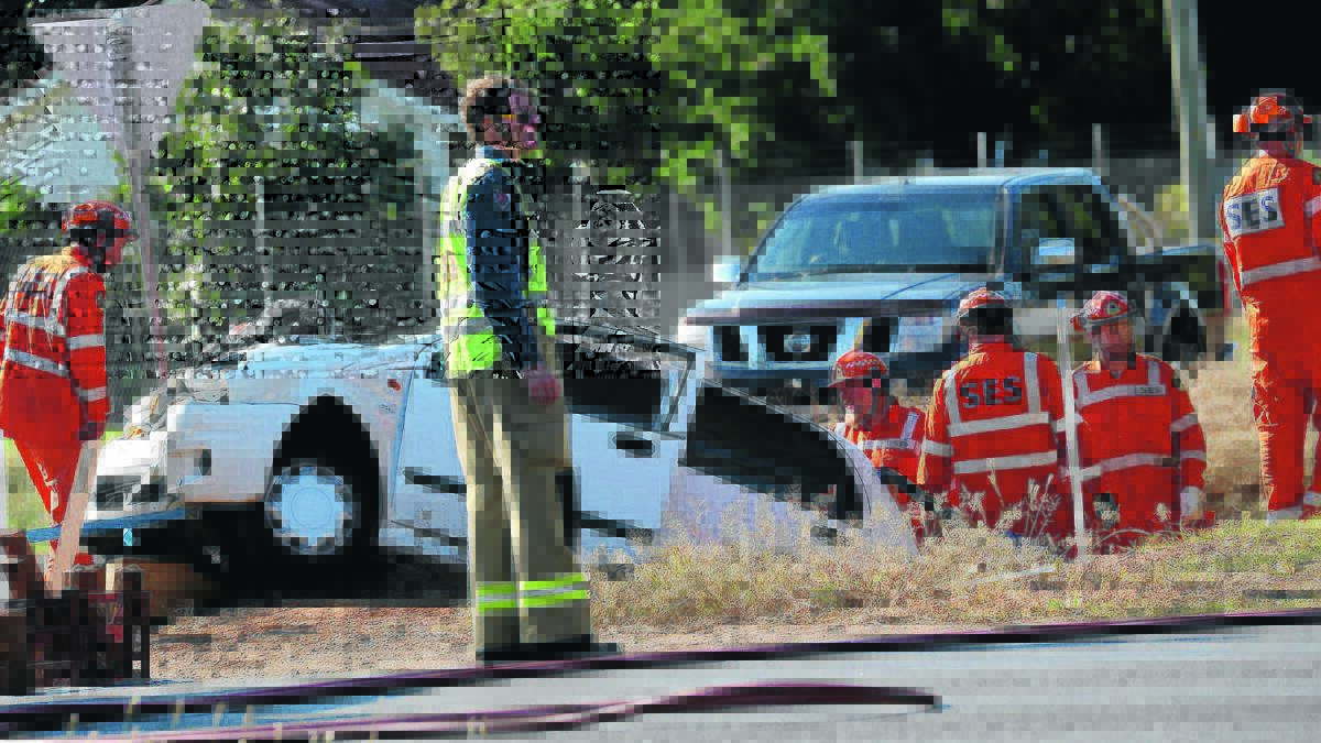 TRAPPED: Emergency services rush to free a woman trapped in her car after a crash at Griffin Avenue on Sunday afternoon. 