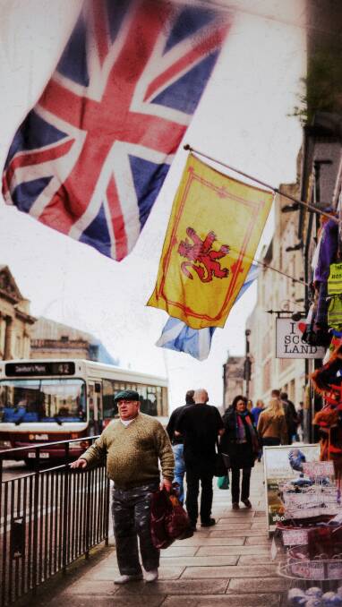 A man walks under Union Jack and Lion Rampant flags on April 23, 2014 in Edinburgh, Scotland. Pic: Jeff J Mitchell/Getty Images