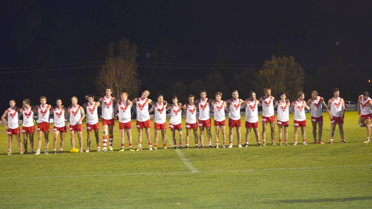 ALL TOGETHER: The Swans line up for the mine's silence prior to Friday night's Anzac clash.
