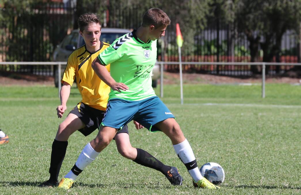 TURNING THE CORNER: Riverina's George Pavese tries to turn his Northern Suburbs FA opponent in the Rhinos' under 15s clash on Saturday.