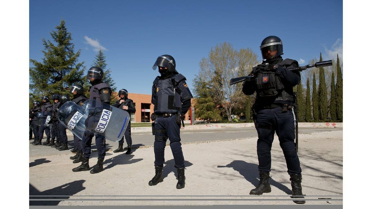 Riot police stand guard around the campus building where some students were arrested during a protest against the government's education reforms and cutbacks in university grants and staffing in Campus Ciudad Universitaria on March 26, 2014 in Madrid, Spain. Photo: Getty Images.