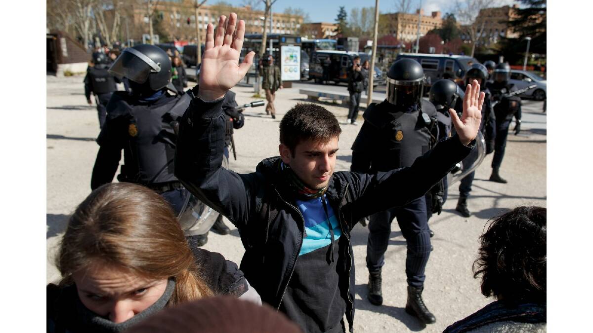 Riot police remove protesters outside an area near the campus building where some students were arrested during a protest against the government's education reforms and cutbacks in university grants and staffing in Campus Ciudad Universitaria on March 26, 2014 in Madrid, Spain. Photo: Getty Images.