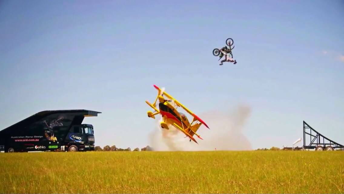 DARE-DEVIL: Griffith motocross rider Joel Brown backflips over a stunt plane.