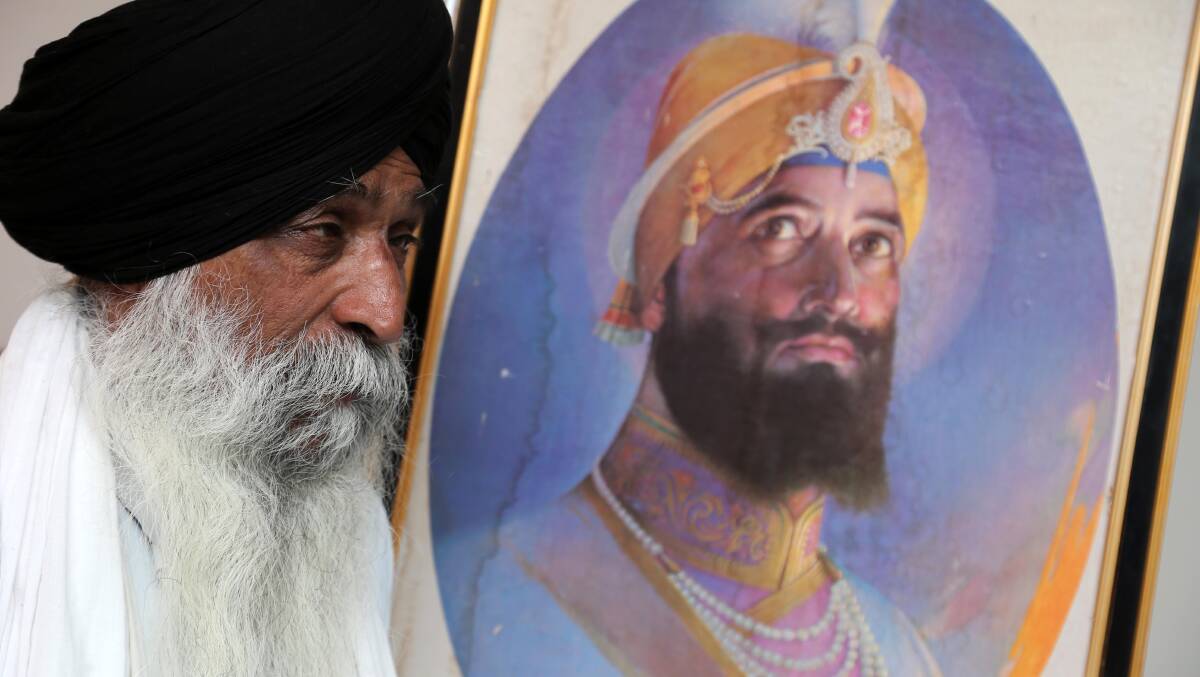 CALL FOR CALM: Mohan Singh, pictured with a photo of Sikh Guru Gobind Singh Ji, hopes the Sydney siege doesn't result in racially motivated attacks in Griffifth. Picture: Anthony Stipo