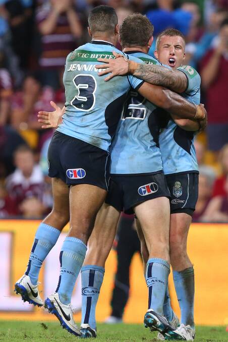 Michael Jennings, Ryan Hoffman and Trent Hodkinson of the Blues celebrate after winning game one of the State of Origin.