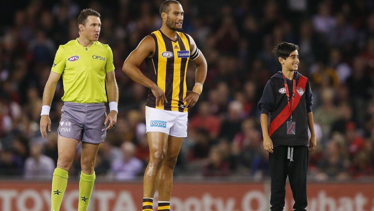 Josh Gibson of the Hawks waits for the toss of the coin next to a Bombers fan during the AFL Round two match between the Essendon Bombers and the Hawthorn Hawks at Etihad Stadium. Picture: Getty