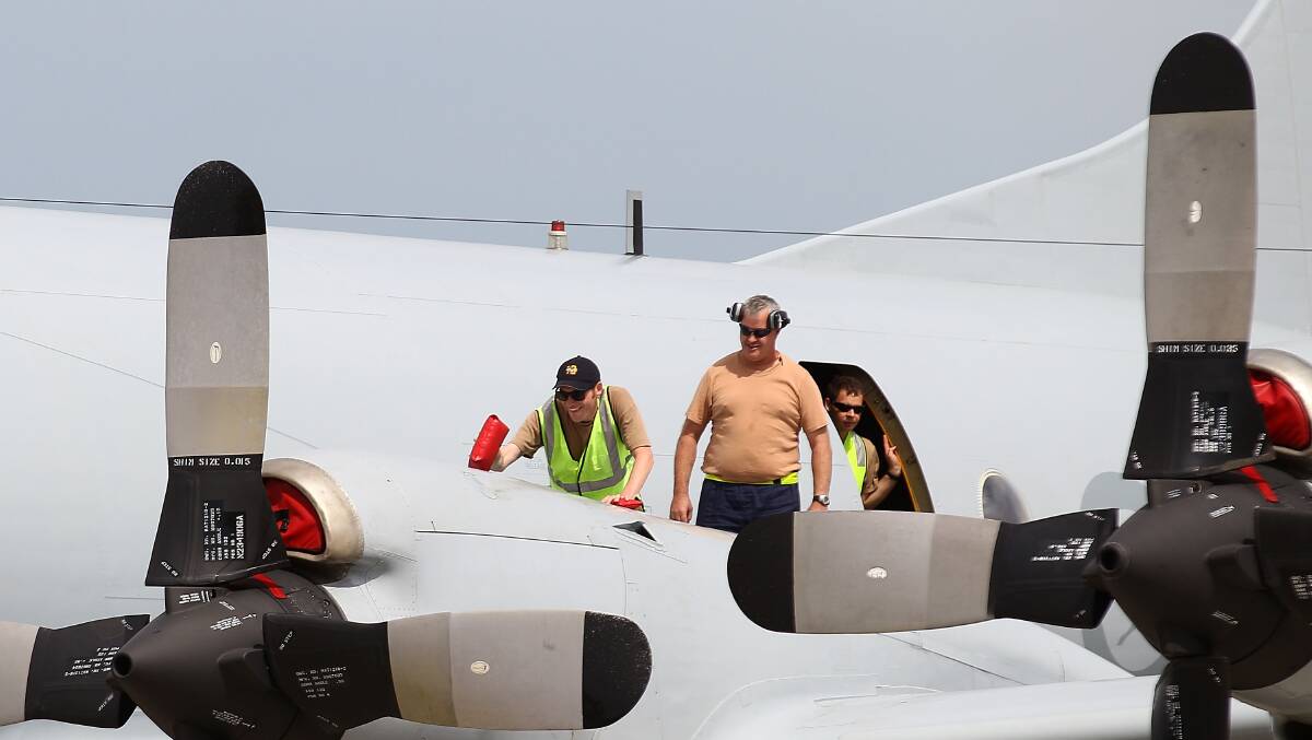  An RAAF ground crew member replaces engine covers on a P3 Orion aircraft at RAAF Base Pearce on March 25, 2014 in Perth, Australia, as the search remains delayed because of bad weather in the search area. Picture: Getty