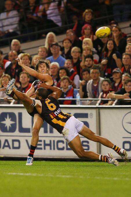 Ben Howlett of the Bombers kicks the ball away from Josh Gibson of the Hawks contest for the ball. Picture: Getty