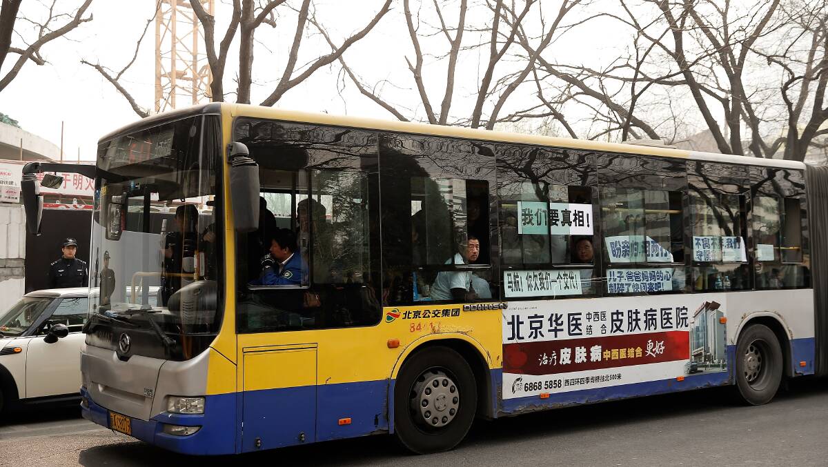 Chinese relatives of the flight MH370 sitting on the bus waiting to go to Malaysia embassy in protest on March 25, 2014 in Beijing, China. Hundreds of protesters, including many relatives of missing flight MH370 passengers, marched on the Malaysian Embassy in Beijing demanding answers from Malaysian authorities about the fate of the flight. Picture: Getty
