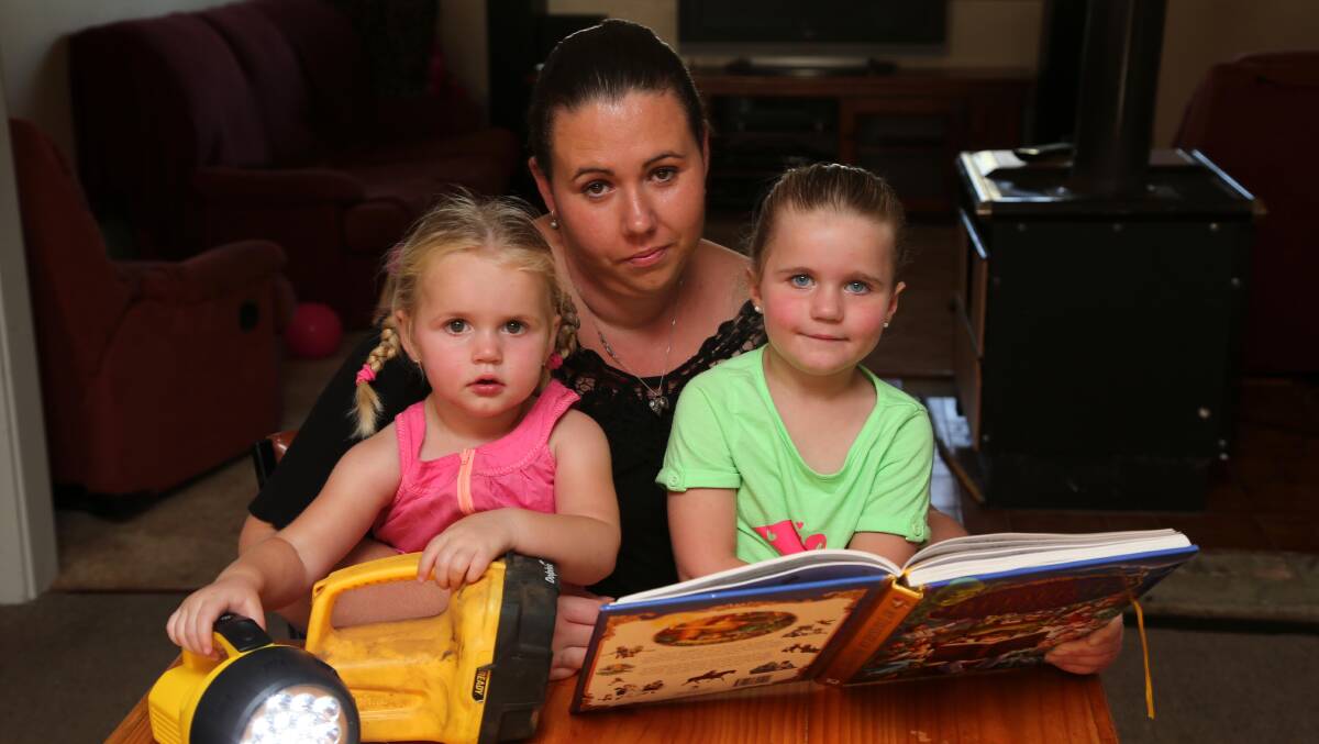 FED UP: Matilda Hornbuckle, 2, with mum Alicia and sister Taylor, 5, have had enough of the repeated blackouts at Barellan
and want something done. Picture: Anthony Stipo