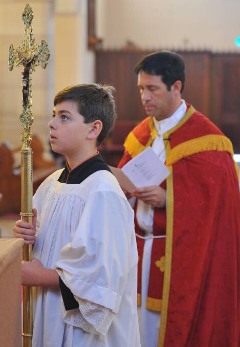 WAGGA: Father Rick Micallef leads the Stations of the Cross Easter celebrations at St Michael's Cathedral on Good Friday. He was assisted by cross bearer Gerard Letchford,12. Picture: Kieren L Tilly, The Daily Advertiser